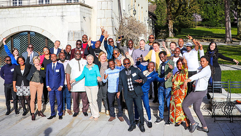 Un groupe de participants souriants à l'extérieur après un cours d'épidémiologie, devant un bâtiment et un cadre verdoyant