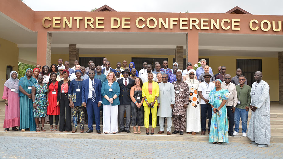 Un groupe de participants devant un Centre de Conférence lors d'un événement.