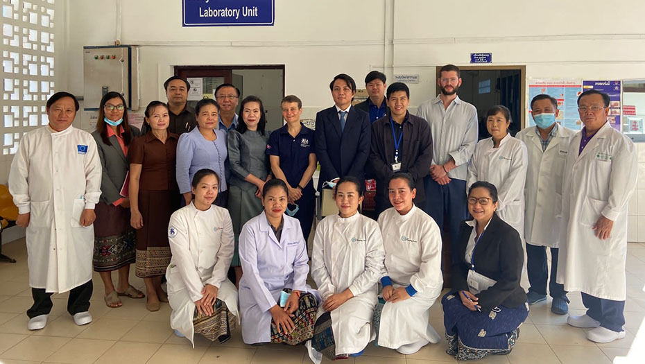 Groupe d’environ 18 personnes posant dans une unité de laboratoire à l’hôpital de Luang Prabang, devant un panneau indiquant Laboratory Unit.